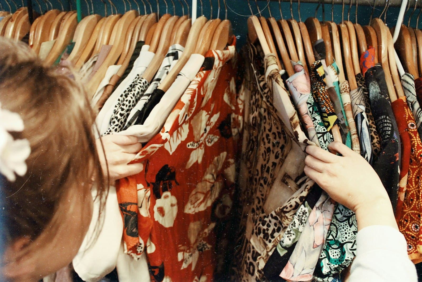 A shopper browsing racks of patterned clothing in a shop